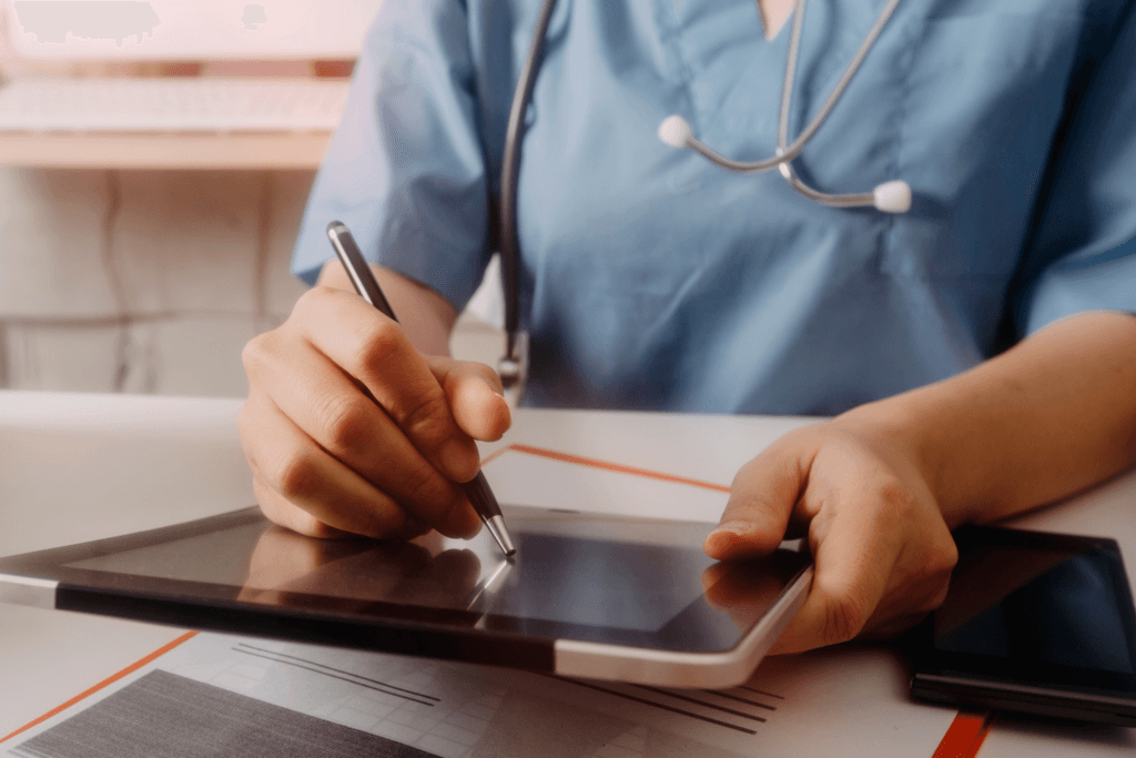 Healthcare professional entering records on a digital tablet